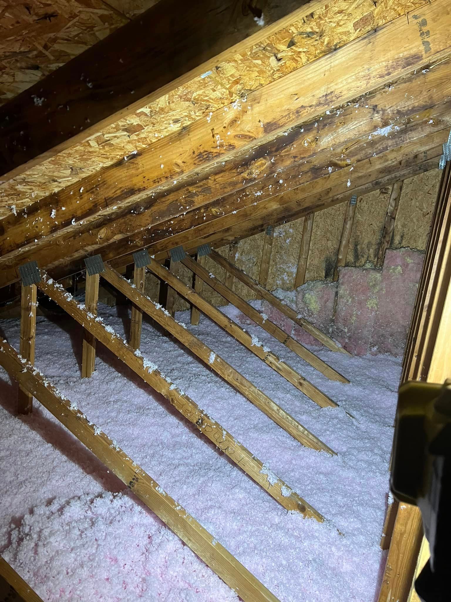 There is a lot of insulation in the attic of a house.