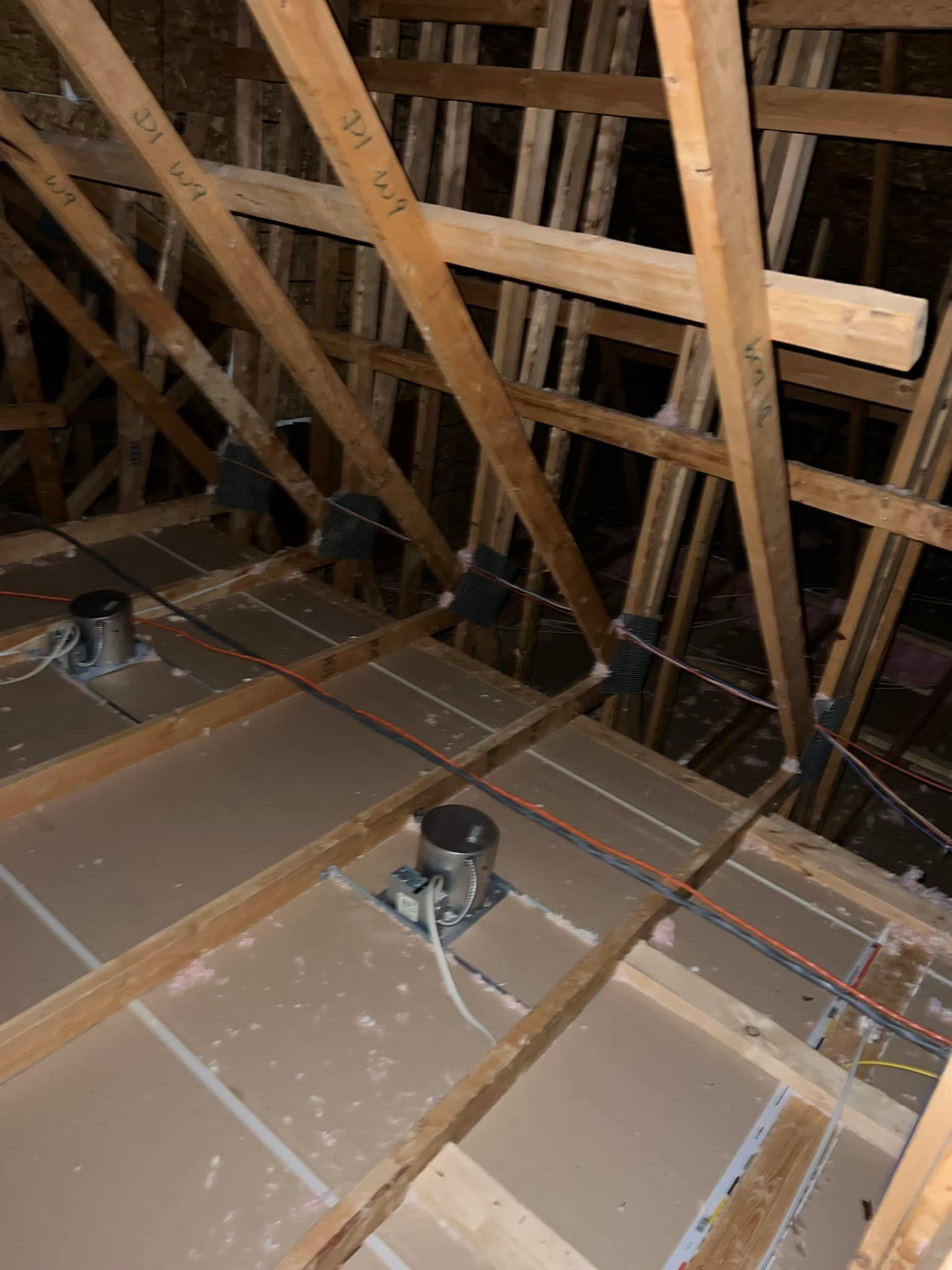 A ceiling with a lot of wooden beams and wires.