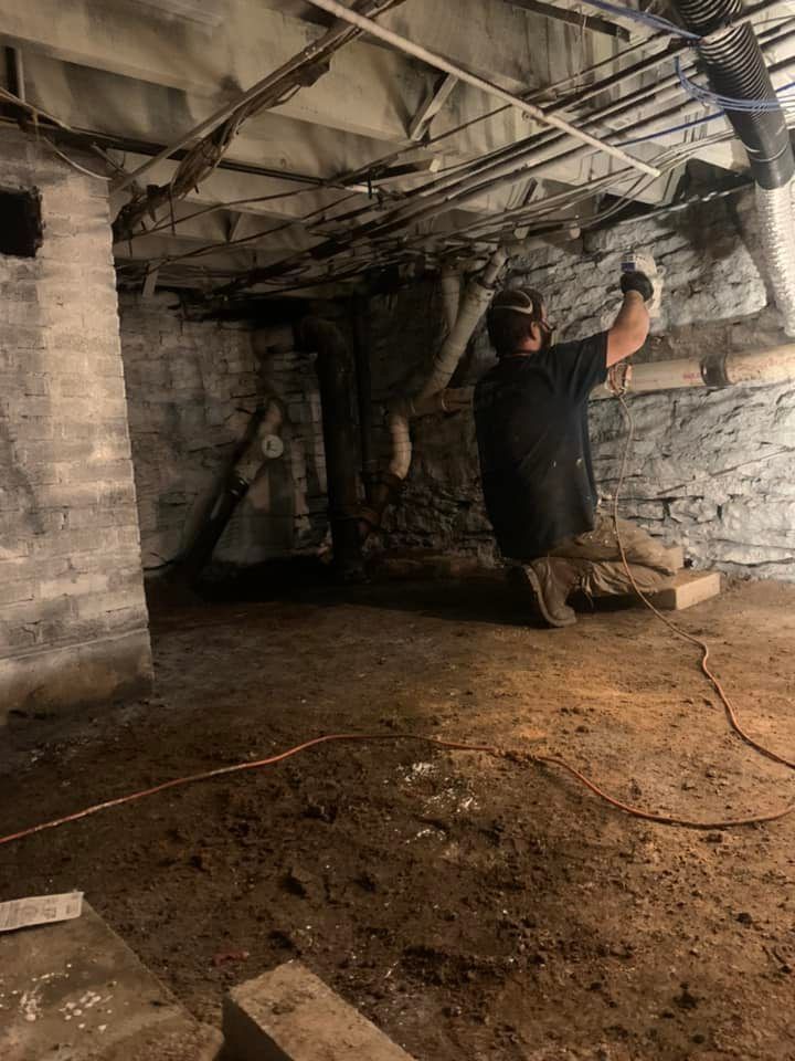 A man is working in a basement with a shovel.