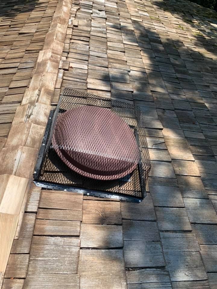 A wooden roof with a vent on top of it.