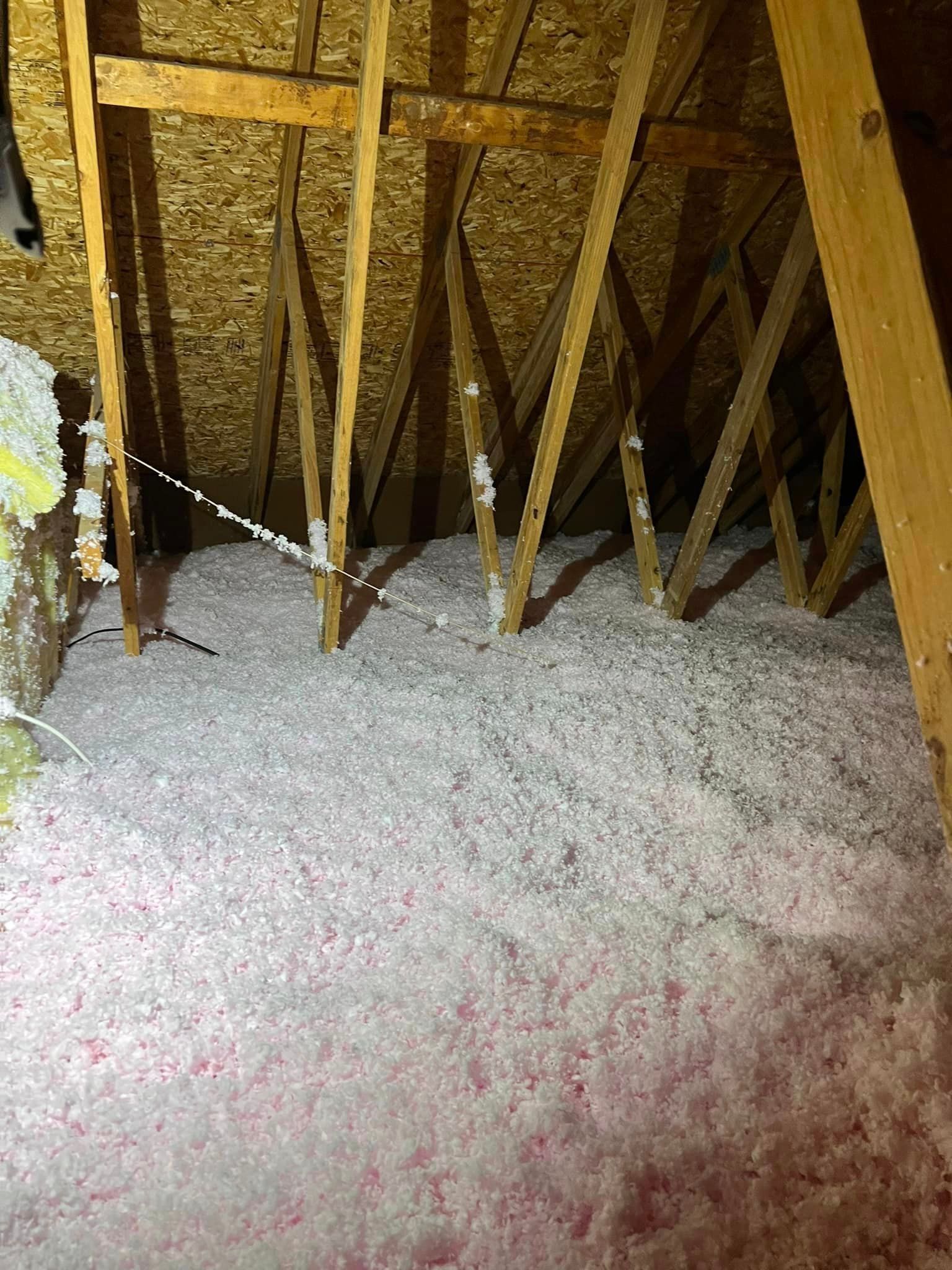 There is a lot of insulation in the attic of a house.