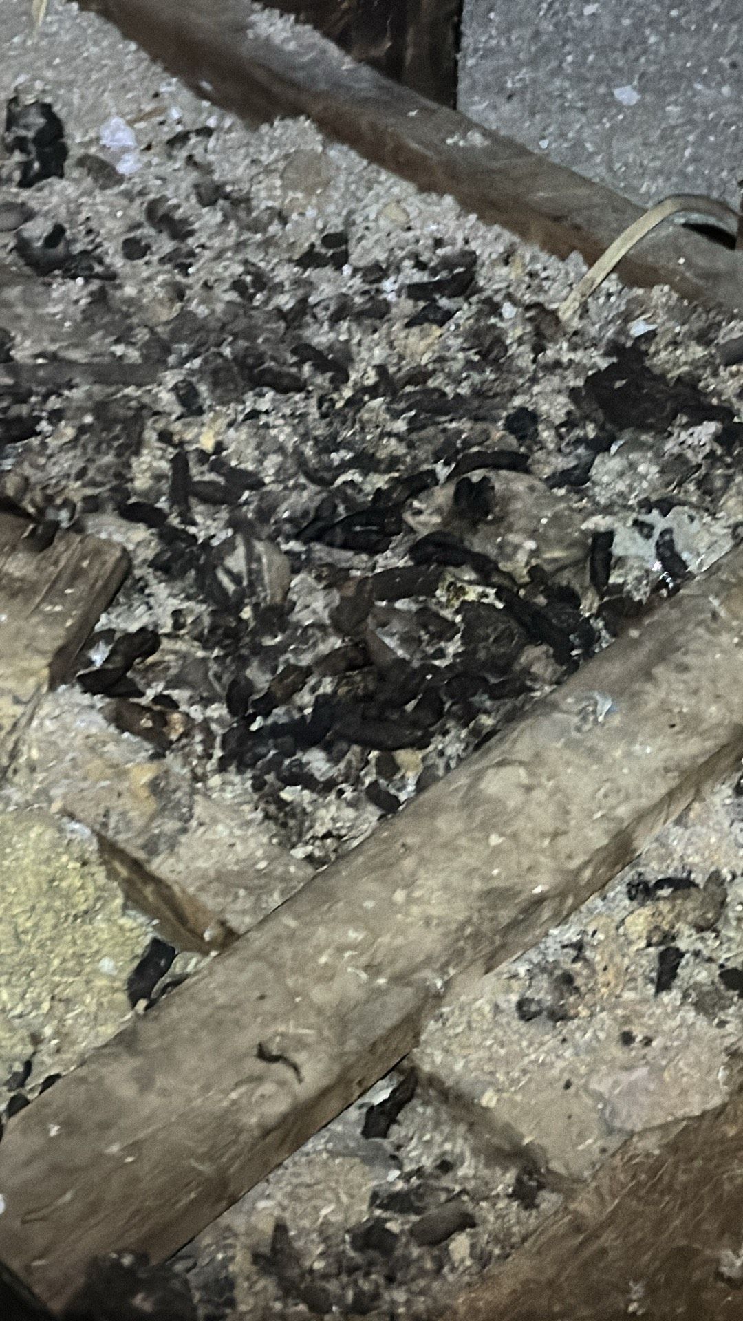 A close up of a pile of ash on a wooden table.