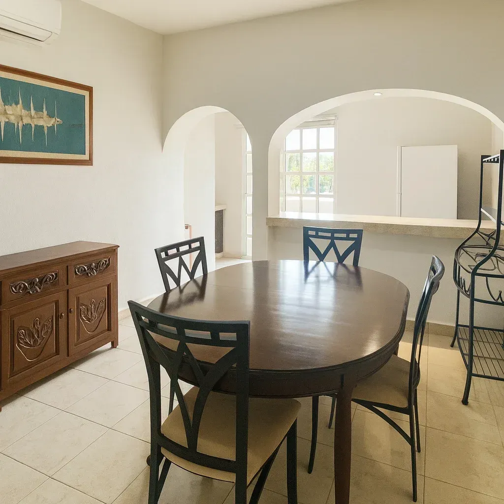 Dining room with oval table, chairs, buffet, arched doorways, and window.