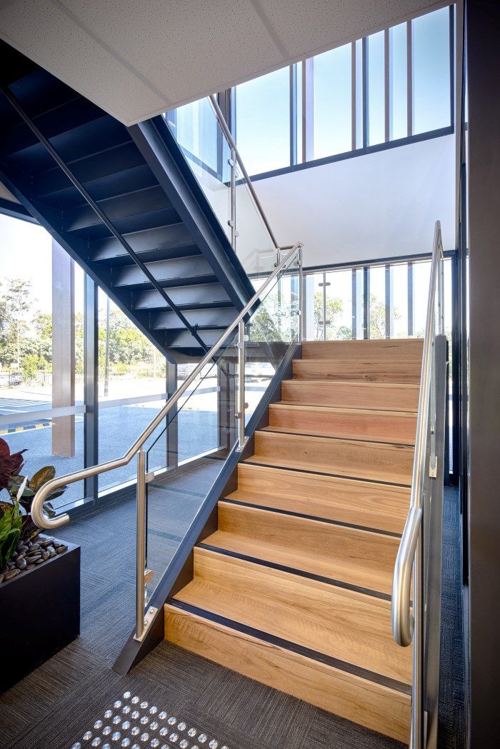 Wooden Staircase In A Modern Building With Glass Walls And Metal Railings — Zeal Interiors in South Grafton, NSW