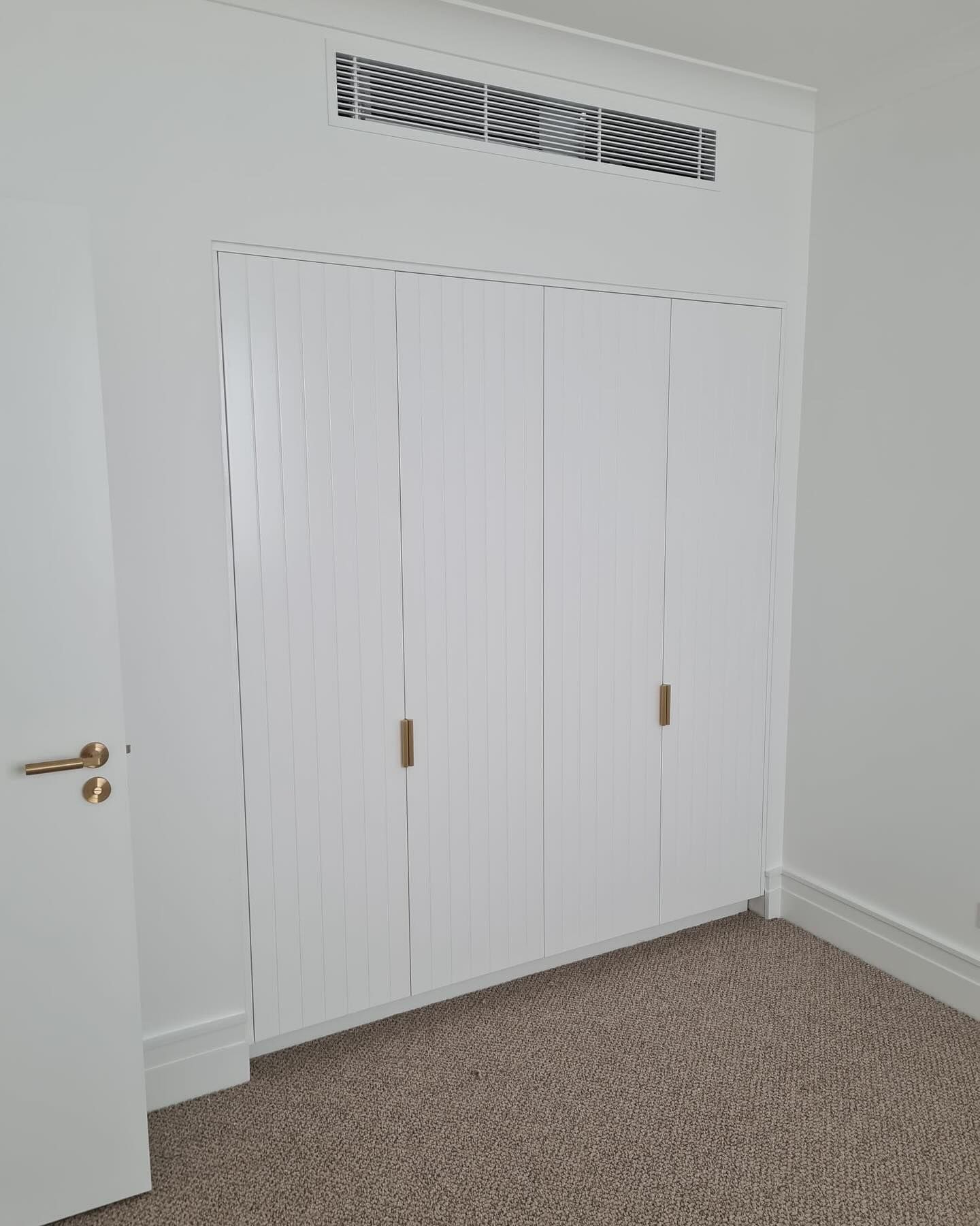 White Closet with Ridged Doors and Brass Handles — Zeal Interiors in Coffs Harbour, NSW