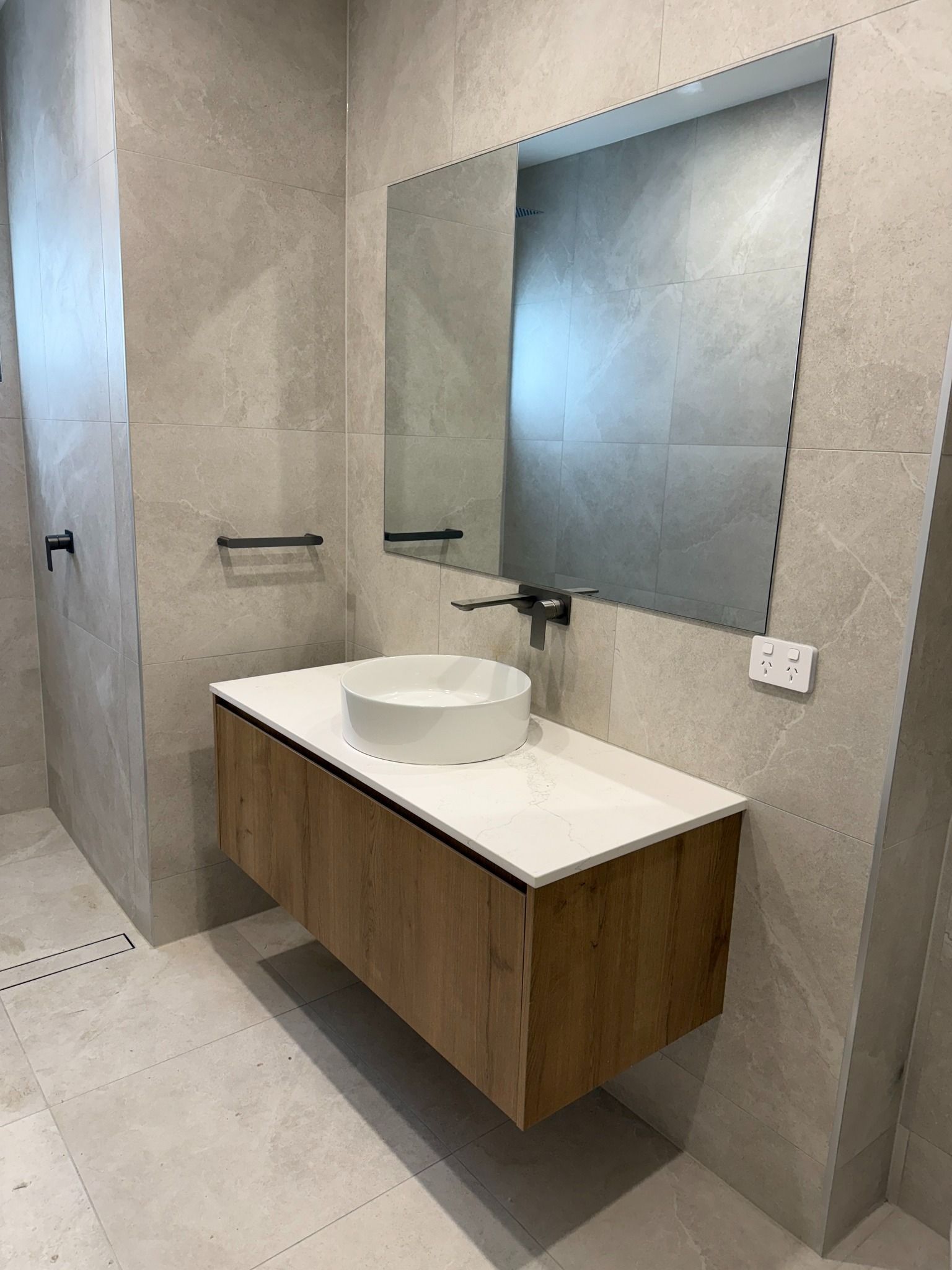 Modern Bathroom With Wooden Vanity, White Countertop, Round Sink, and Large Mirror — Zeal Interiors in Brisbane, NSW