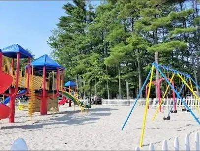 Chimney sweep portland maine - Colorful playground equipment and swings sit on a sandy surface surrounded by tall green trees and a white picket fence.