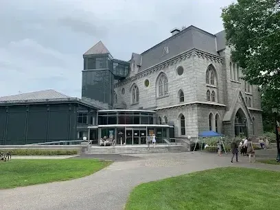 Chimney sweep portland maine-Gothic-style stone building with modern glass entrance on a cloudy day.