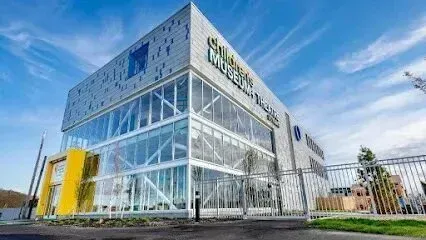 Chimney sweep portland maine-Modern glass-fronted Children's Museum building with blue sky and clouds.