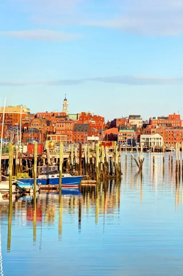 Chimney sweep portland maine - Scenic waterfront view featuring colorful buildings, wooden piers, and boats reflecting in calm water under a clear blue sky.