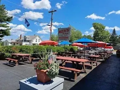 Chimney sweep portland maine - Outdoor dining area with numerous picnic tables under red and blue umbrellas at Ken's Place seafood restaurant.