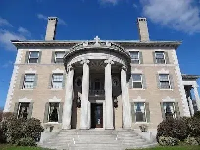 Chimney sweep portland maine - A grand, multi-story building with a prominent circular portico featuring large columns and a cross at the apex, set against a bright blue sky.
