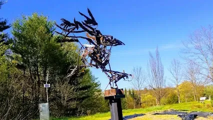 Chimney sweep portland maine - Sculpture of a bird made of metal stands outdoors under a bright blue sky.