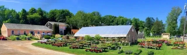 Chimney sweep portland maine - Panoramic view of a garden center with greenhouses, plants, and buildings under a clear blue sky.