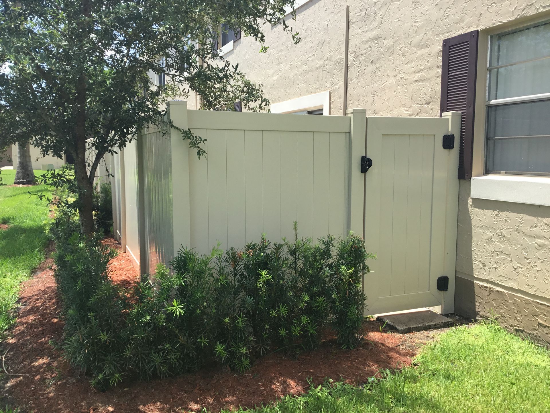 A white fence with a gate in front of a building