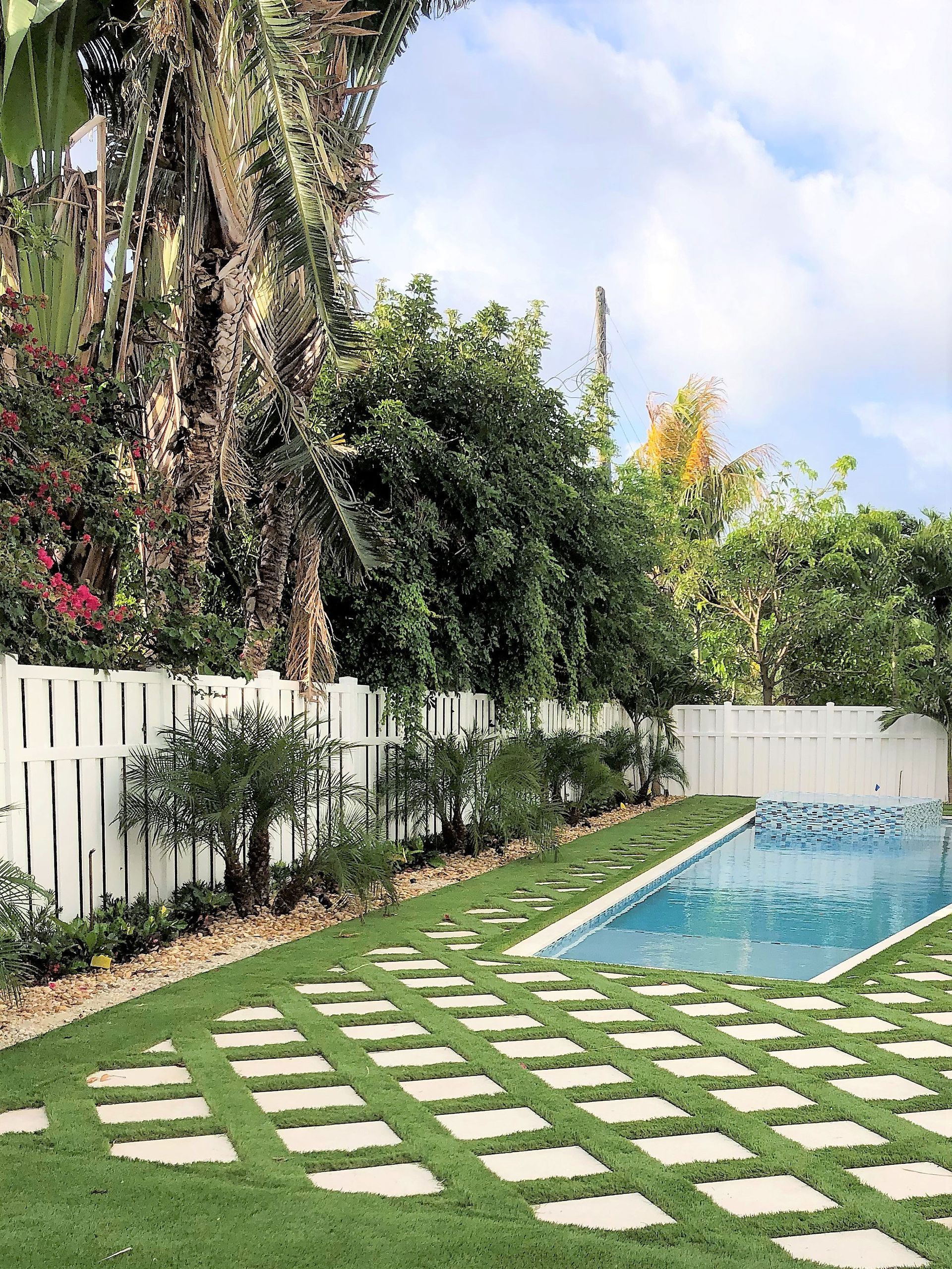 There is a large swimming pool in the backyard of a house.