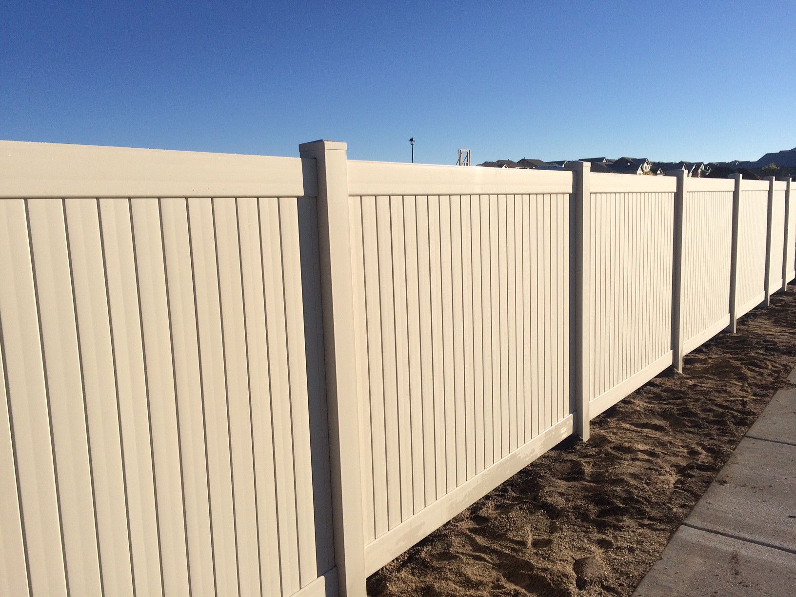 A white fence with a blue sky in the background