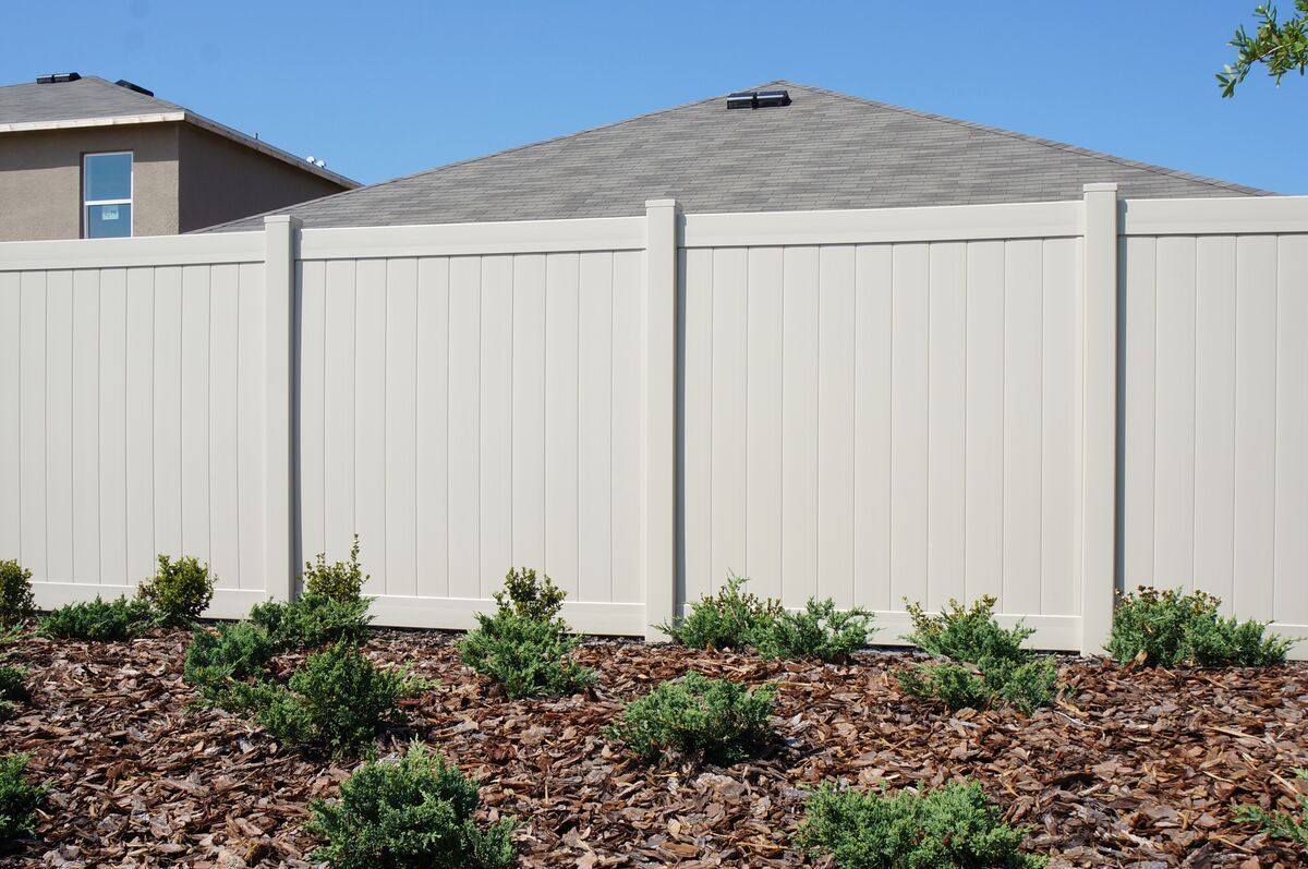 A white fence with a house in the background