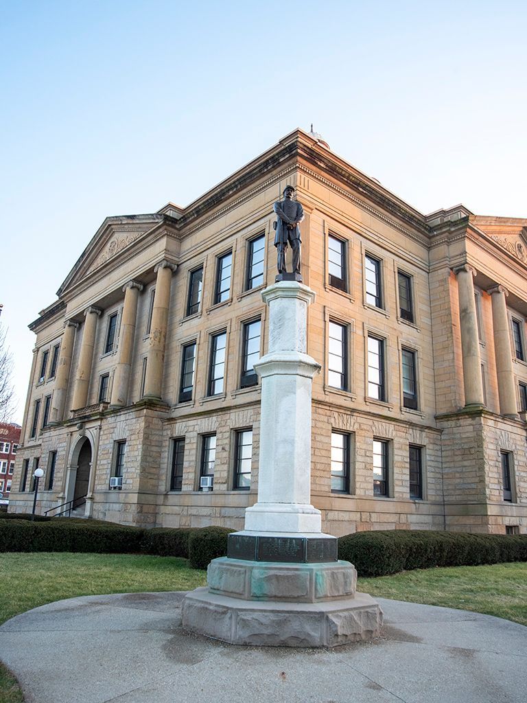 A large brick building with a statue in front of it.