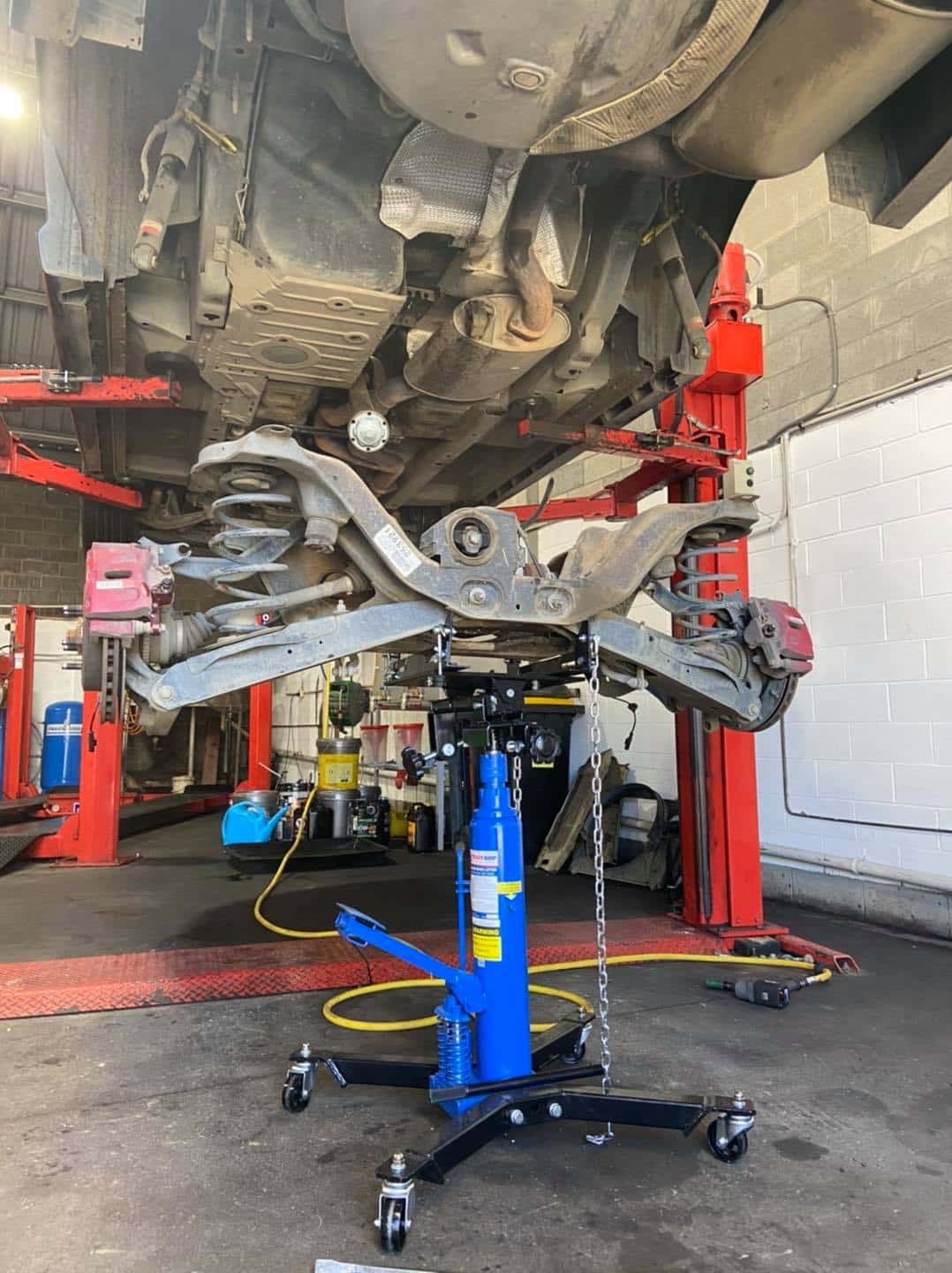 A Car is Sitting on a Lift in a Garage — AA Automotive Repairs in Forster, NSW