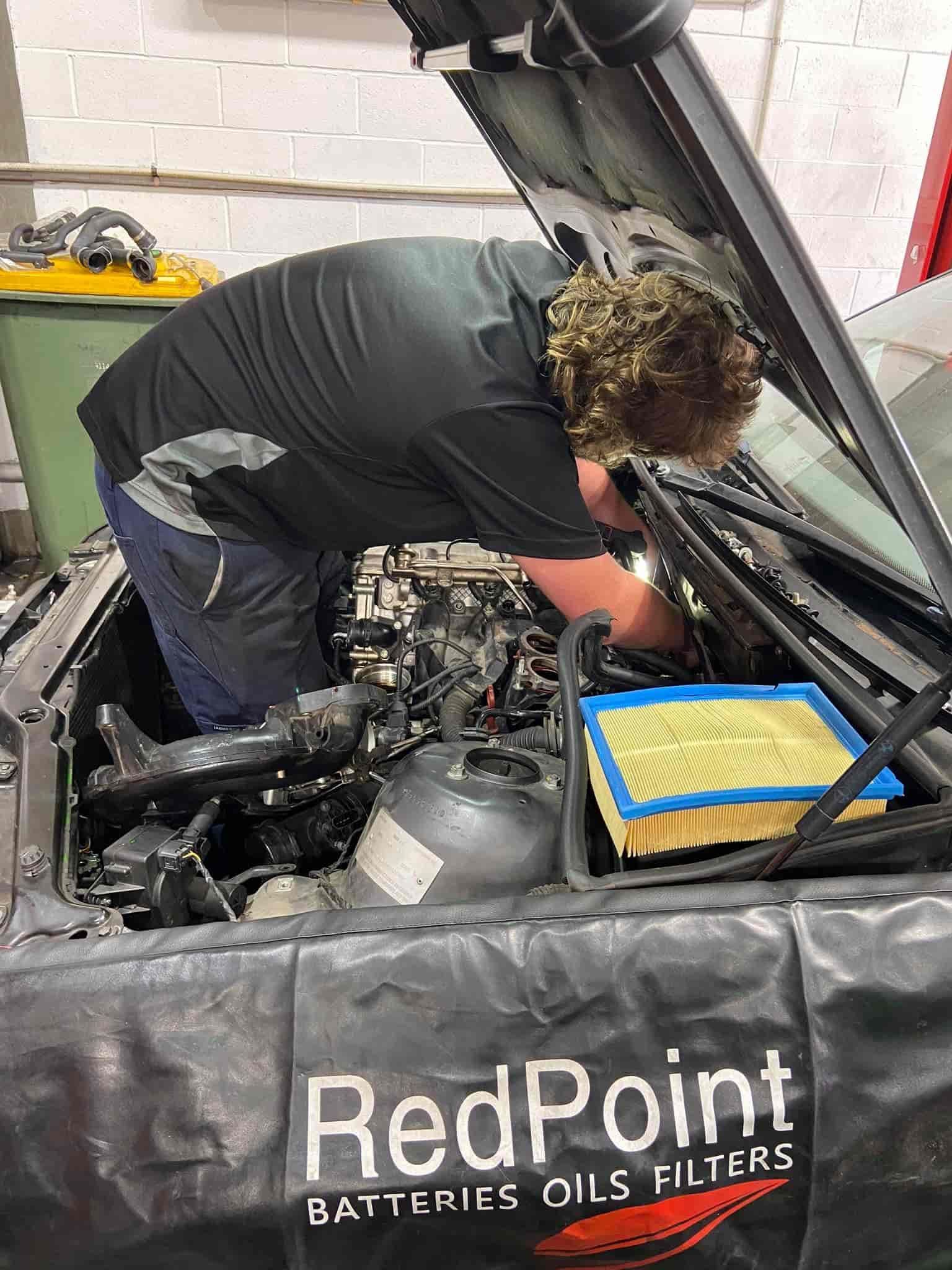 A Man is Working on the Engine of a Car With the Hood Open — AA Automotive Repairs in Forster, NSW