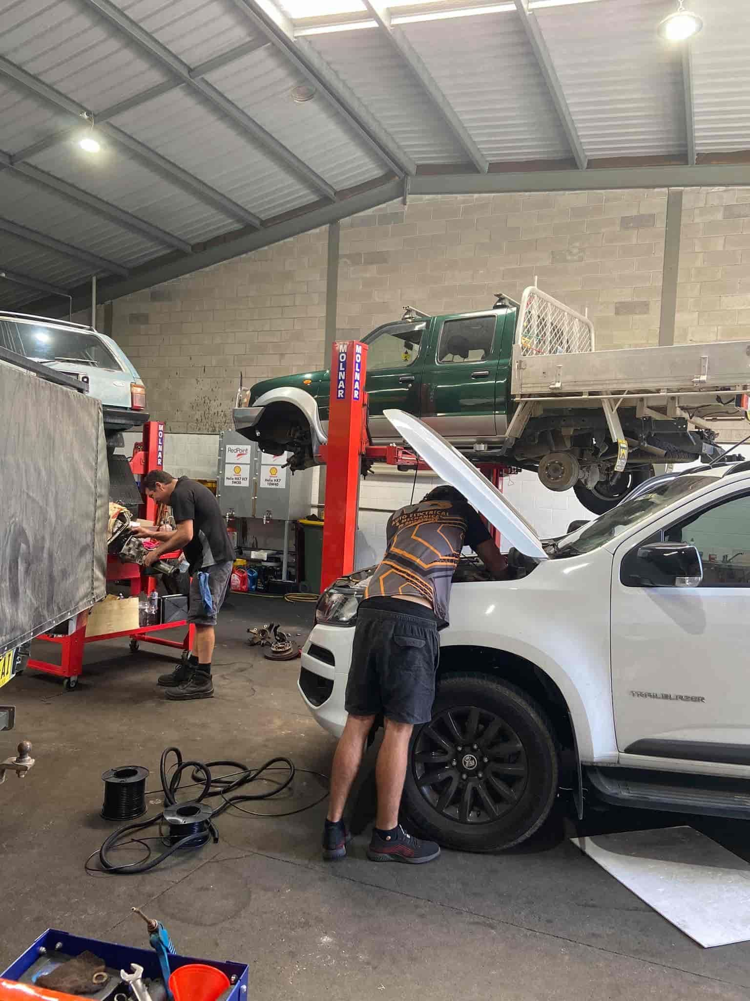 A Man is Working on a Truck in a Garage With the Hood Open — AA Automotive Repairs in Forster, NSW