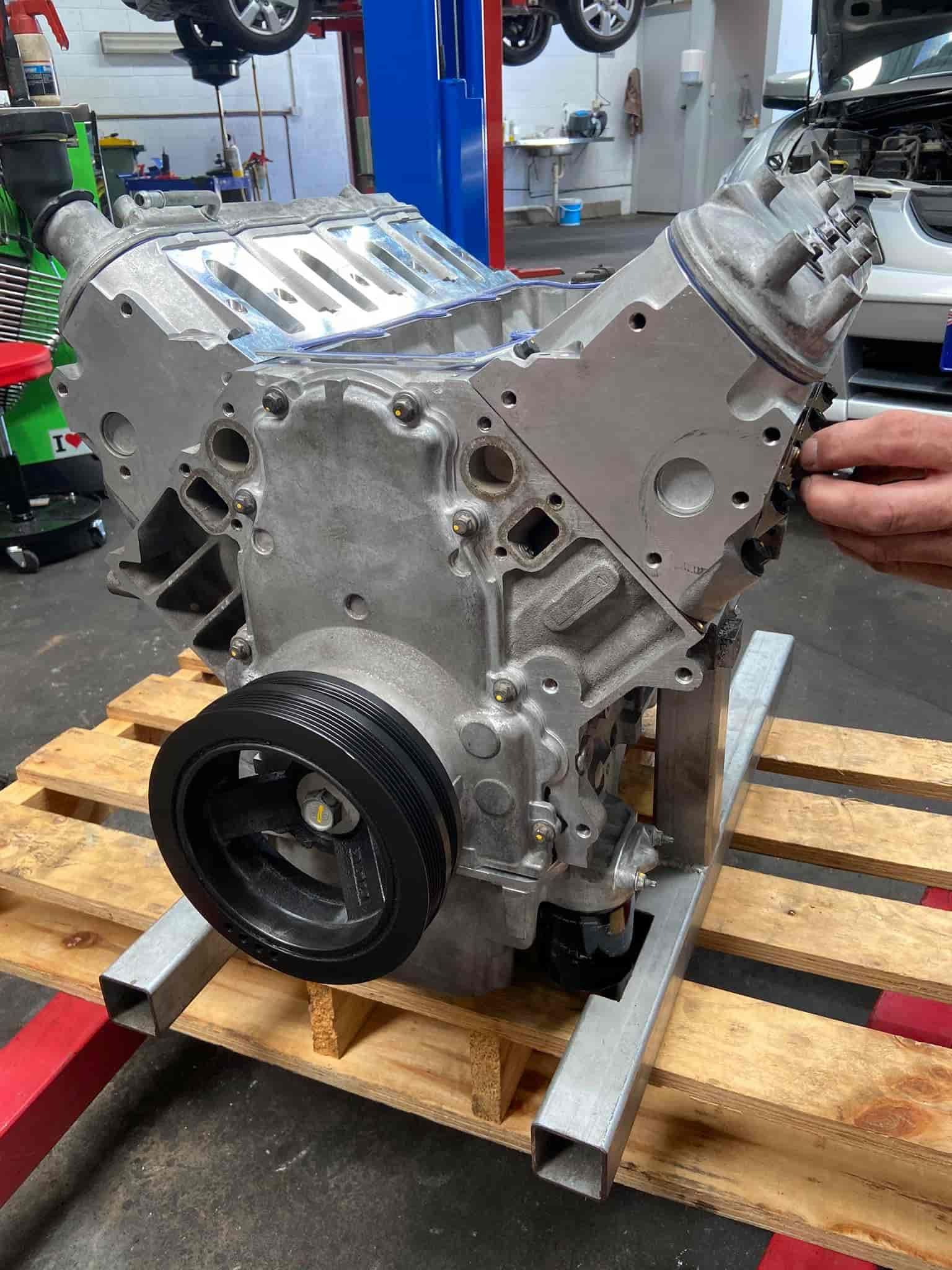 A Person is Working on a Car Engine on a Wooden Pallet — AA Automotive Repairs in Forster, NSW