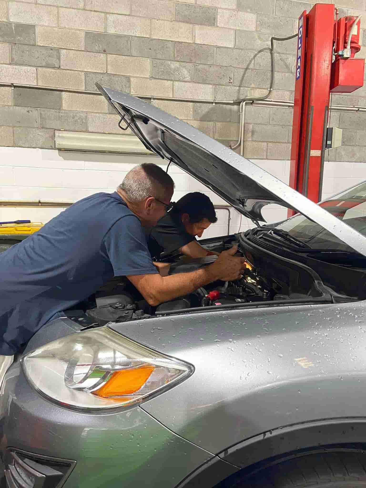 Two Men Are Working on a Car in a Garage With the Hood Open — AA Automotive Repairs in Forster, NSW