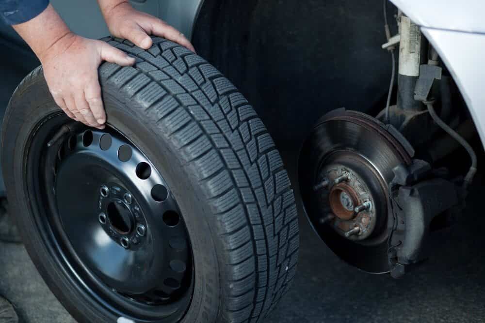 A Person is Changing a Tyre on a Car — AA Automotive Repairs in Forster, NSW