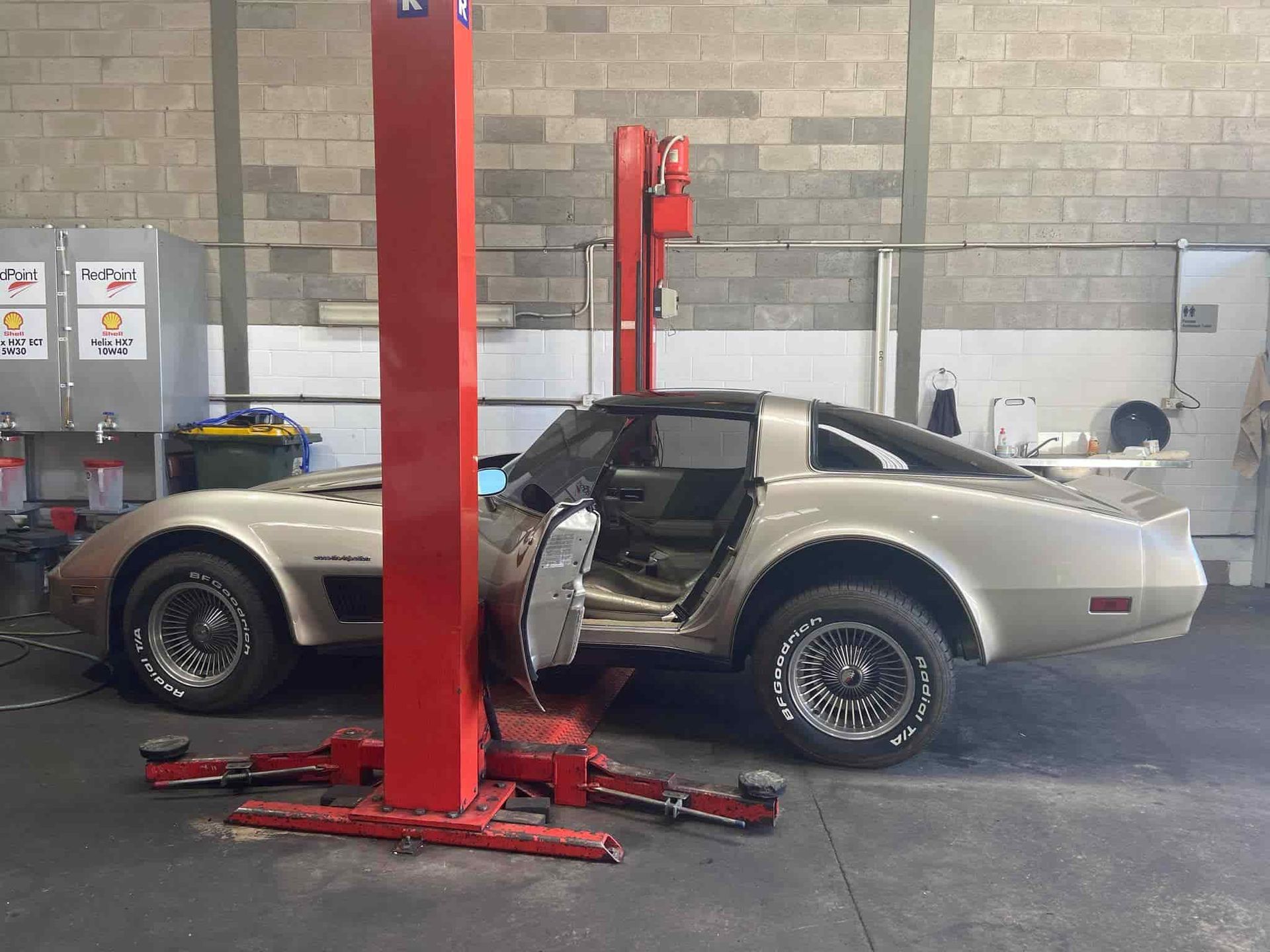 A Car is Sitting on a Red Lift in a Garage — AA Automotive Repairs in Forster, NSW