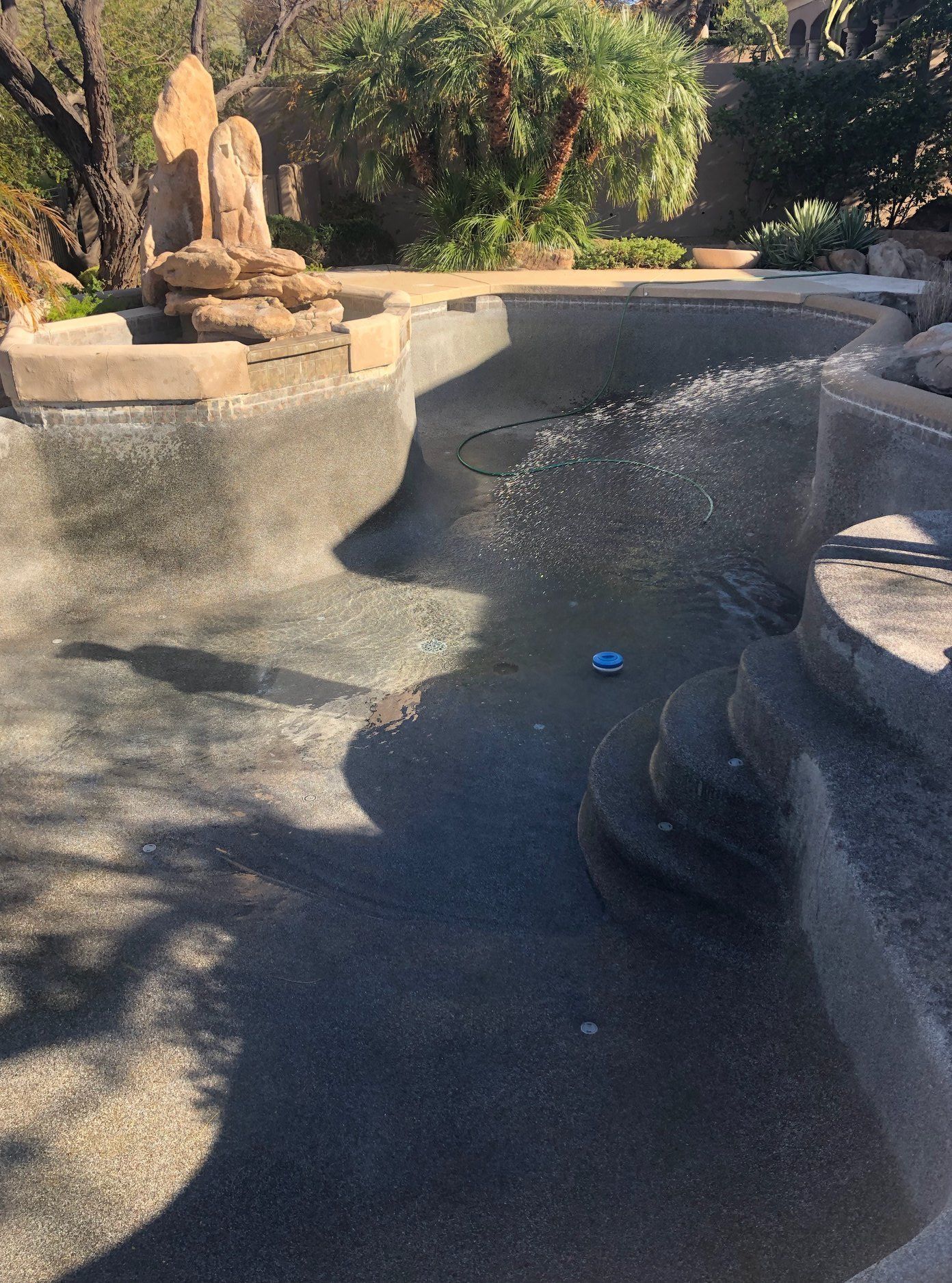 A swimming pool with a fountain in the middle of it.