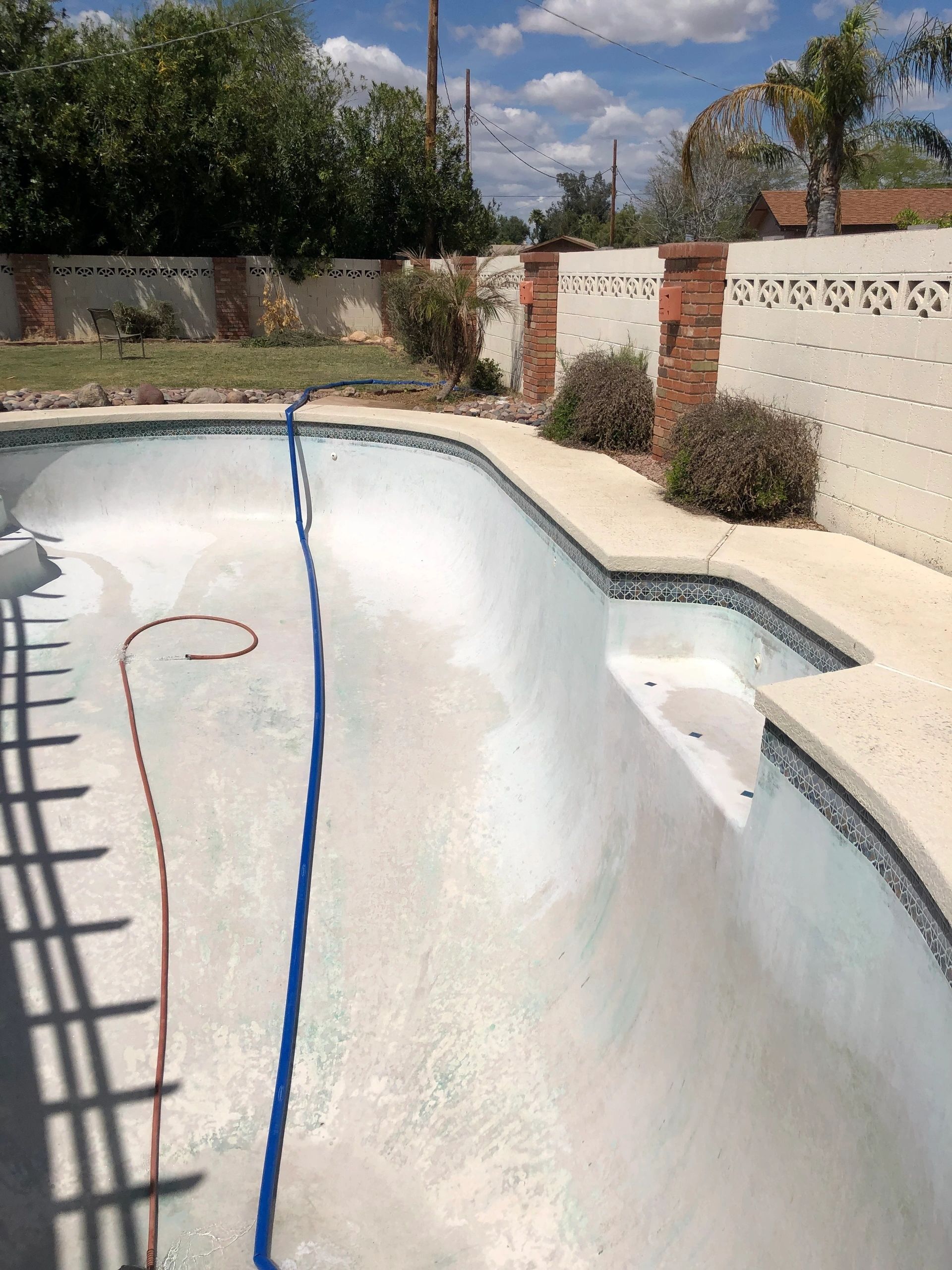 An empty swimming pool with a hose attached to it.