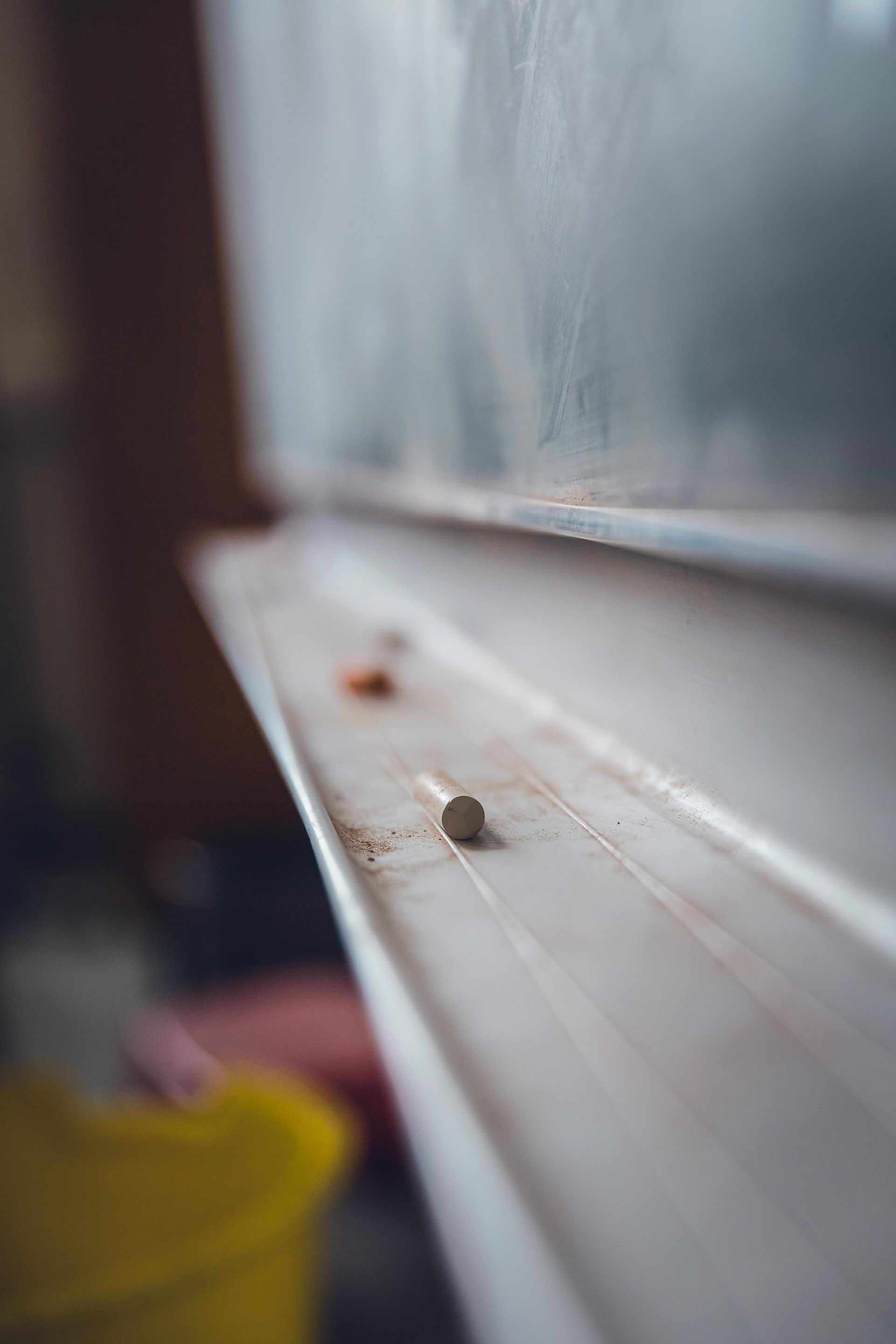A close up of a window sill with a yellow bucket in the background.