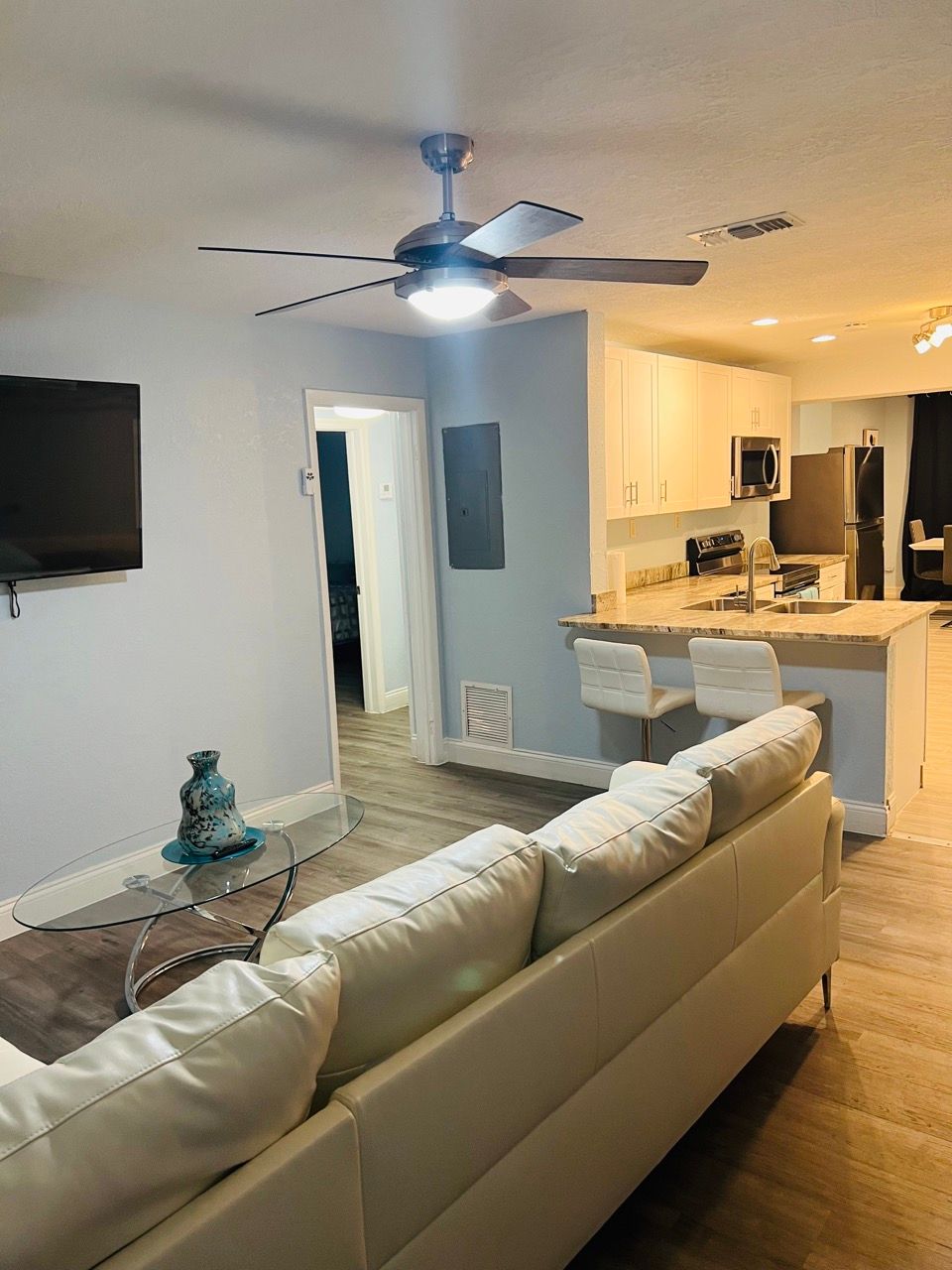 Bedroom with a bed, nightstands, and a door to a closet. Pale green walls, beige carpet, and natural light.