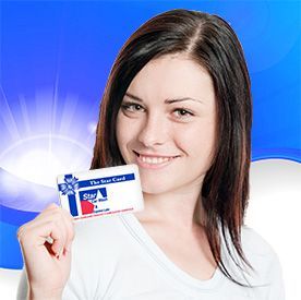 Woman holding a Star of Hope gift card, smiling. Blue background with sunburst effect.