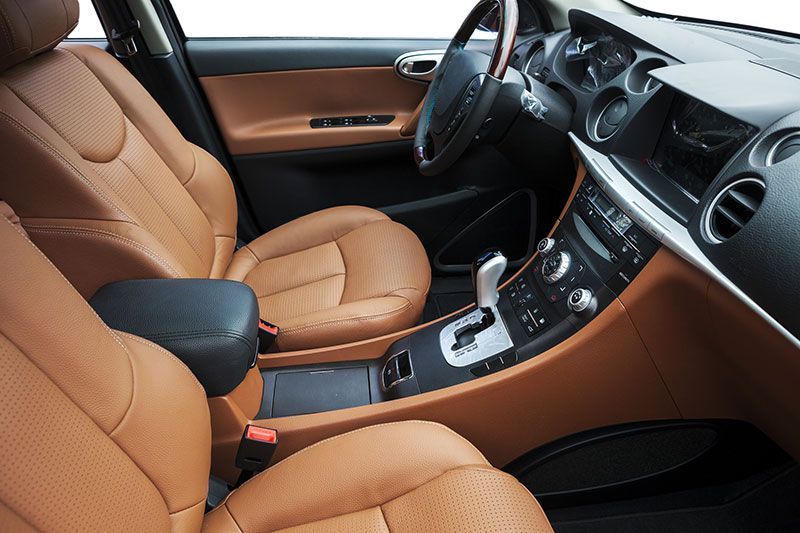 Tan leather car interior with black console and steering wheel.