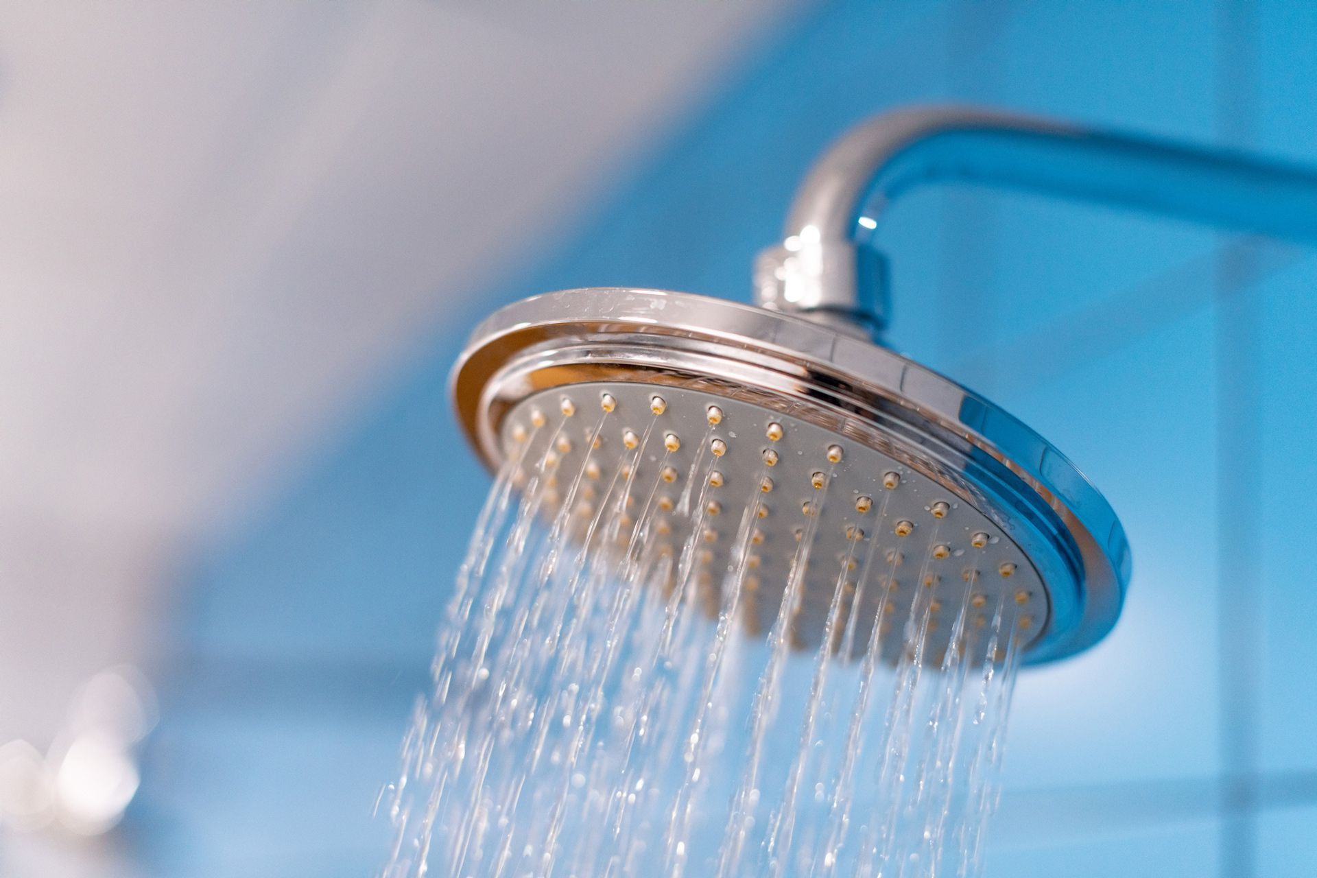 A close up of a shower head with water coming out of it.
