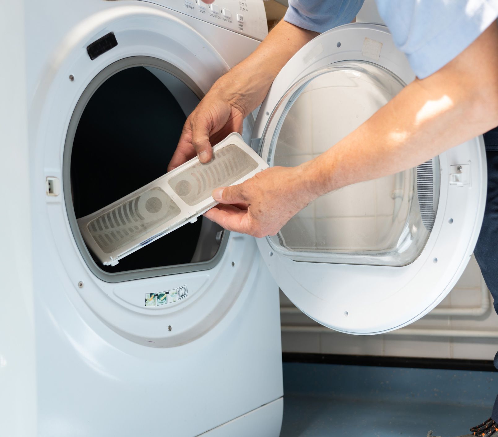 A person is taking a filter out of a dryer