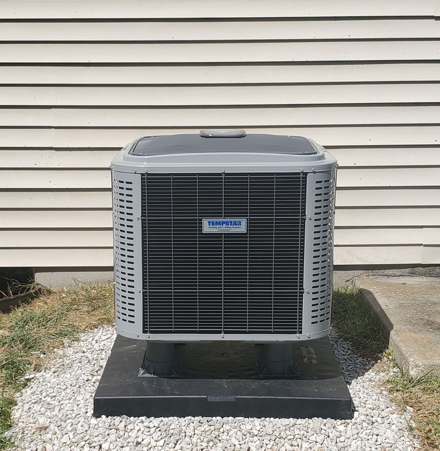 A tornado air conditioner is sitting outside of a house