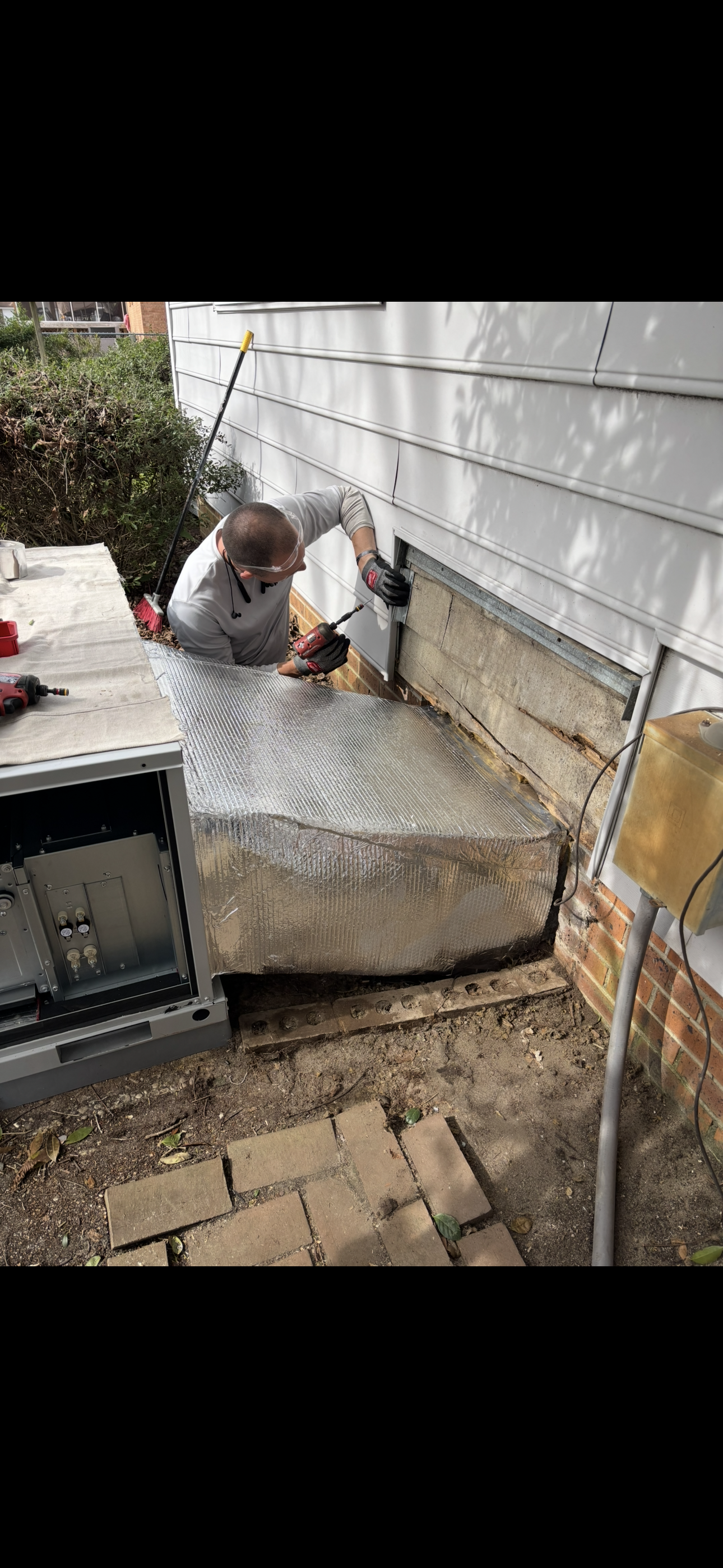 A man is working on the side of a house.