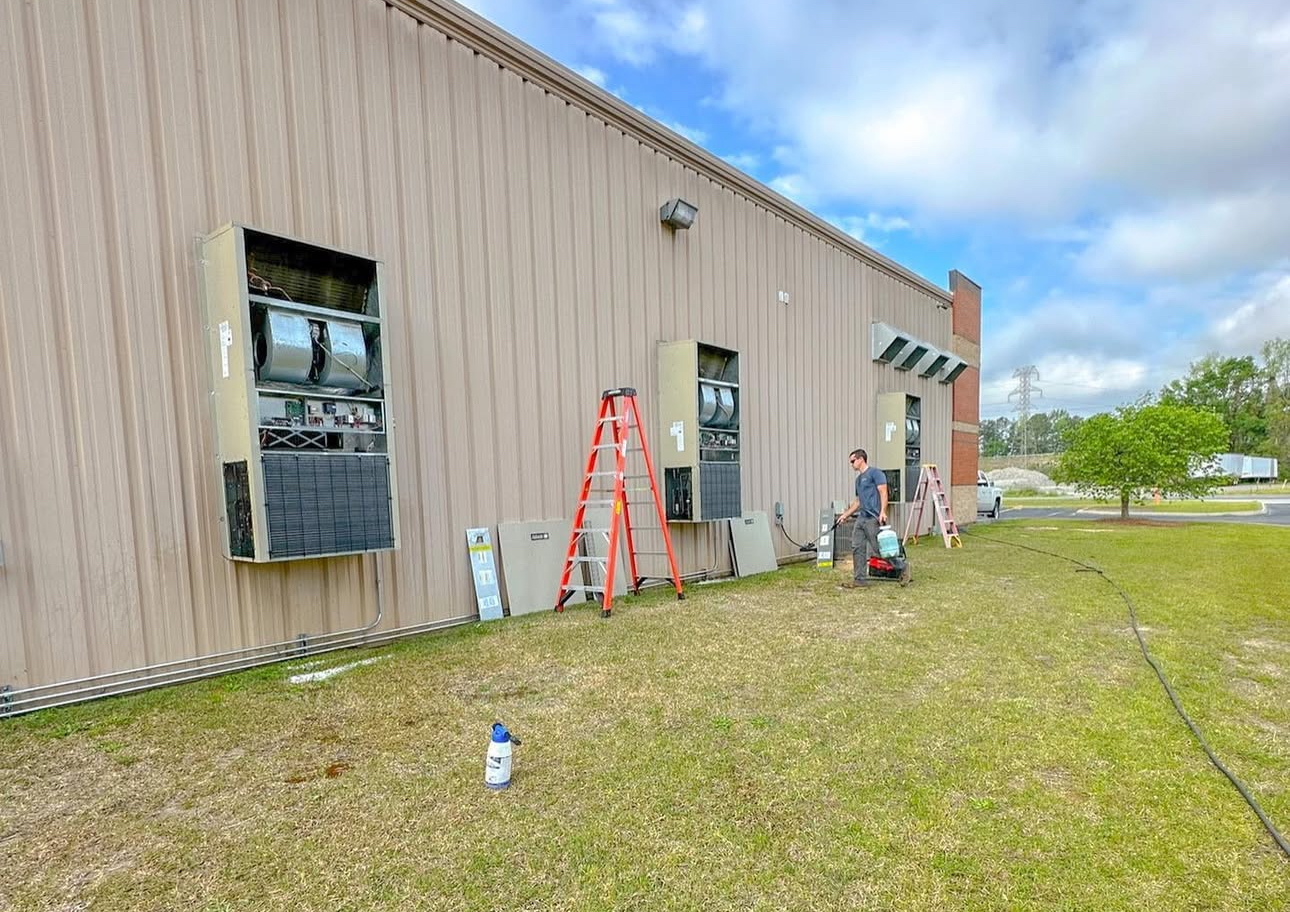 A man is standing on a ladder in front of a building.