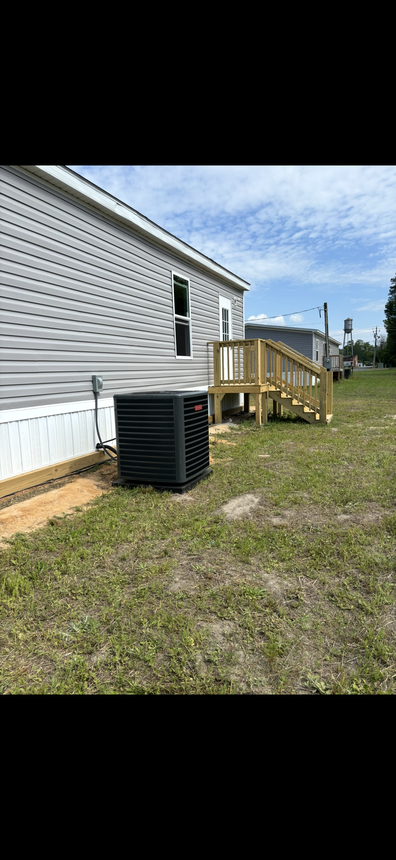 A mobile home with a heater and a ramp in front of it.