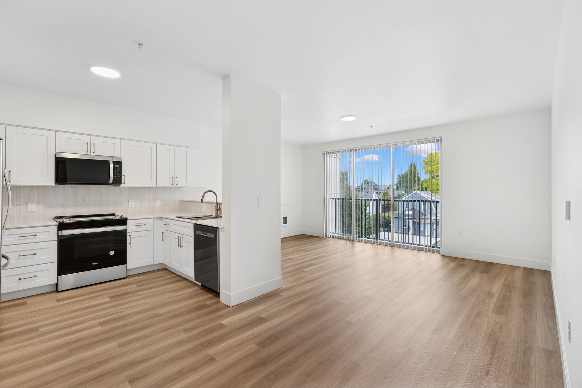 view of kitchen and living area with white cabinets and light flooring