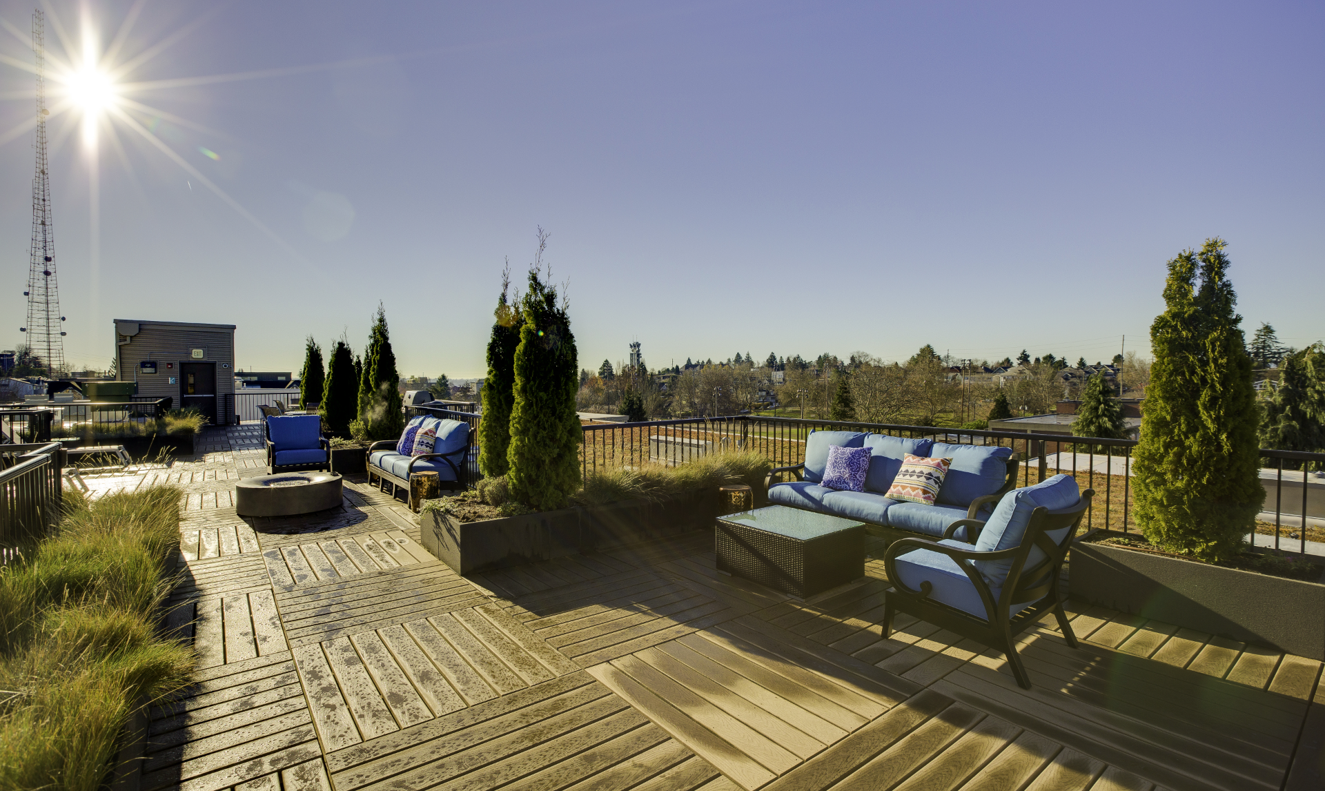 A rooftop deck with a couch and chairs on it