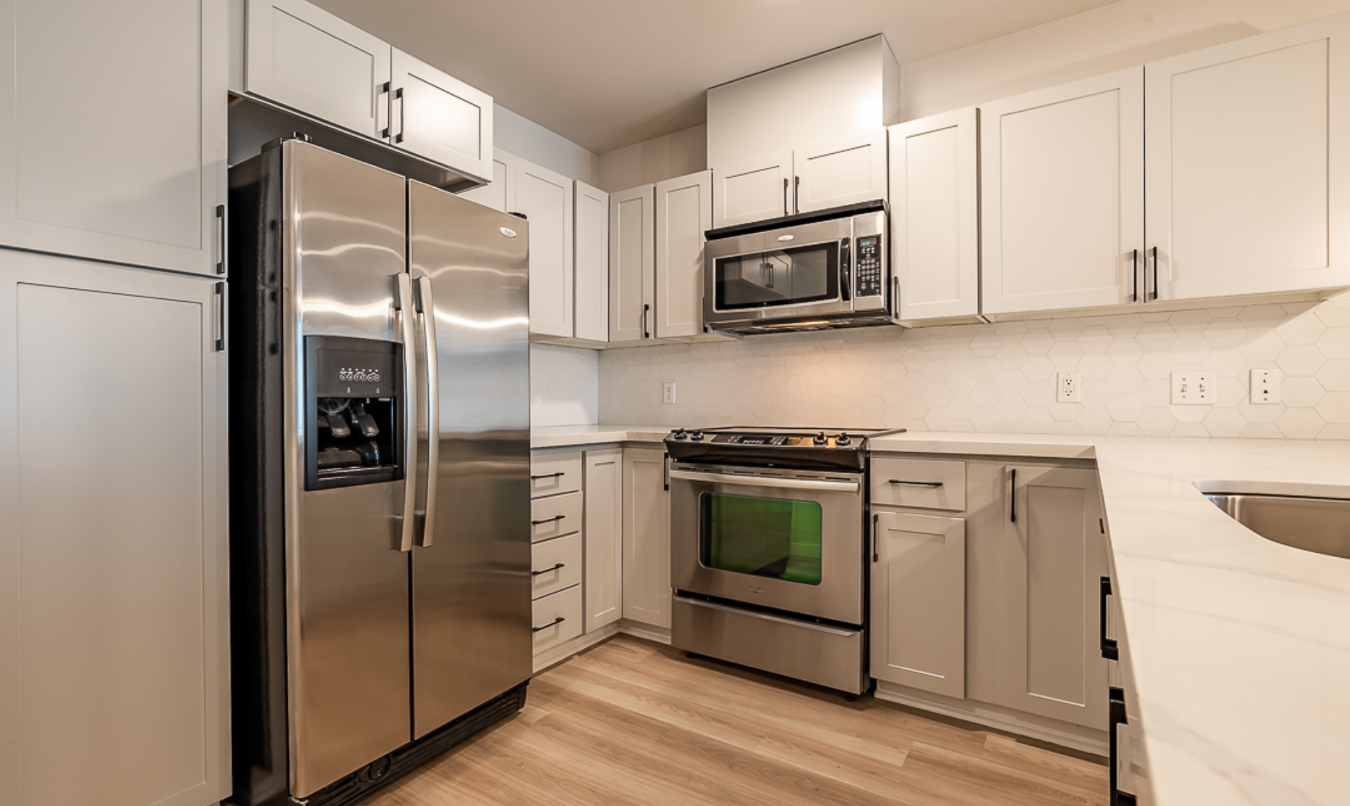 A kitchen with stainless steel appliances and white cabinets.