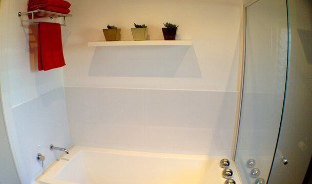 Modern Bathroom with Red Towels — Builders  in Fernhill, NSW