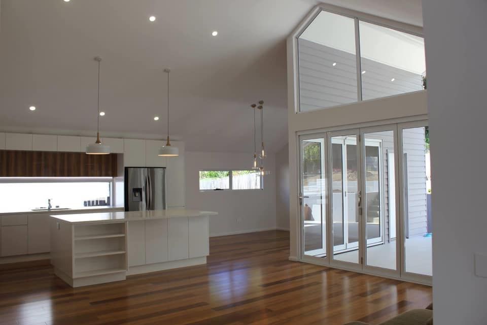 An Empty Kitchen With a Large Island and Lots of Windows — Craig Allman Construction Pty Ltd In Fernhill, NSW