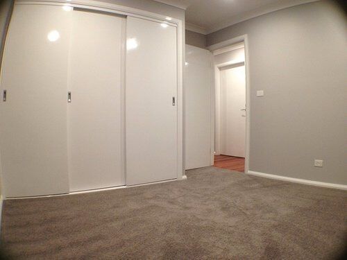Carpeted Bedroom with White Walls — Builders  in Fernhill, NSW