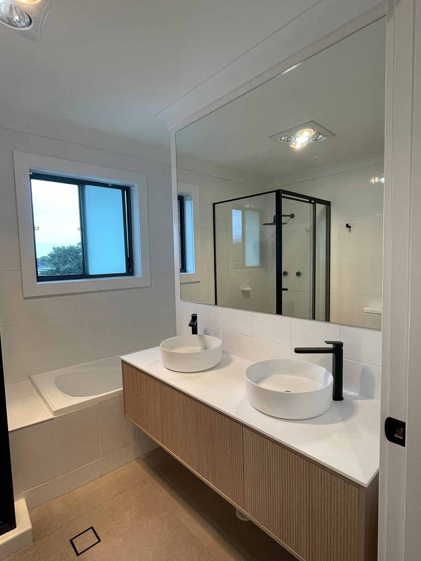 A Bathroom With Two Sinks and a Large Mirror — Craig Allman Construction Pty Ltd In Fernhill, NSW