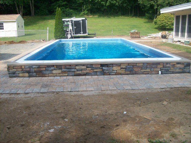 Back yard brick walkway with stone retainer wall for the pool - back yard landscaping services - Stellato Bros. Inc. in Feeding Hills, MA